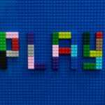 the word play spelled out of legos on a blue surface