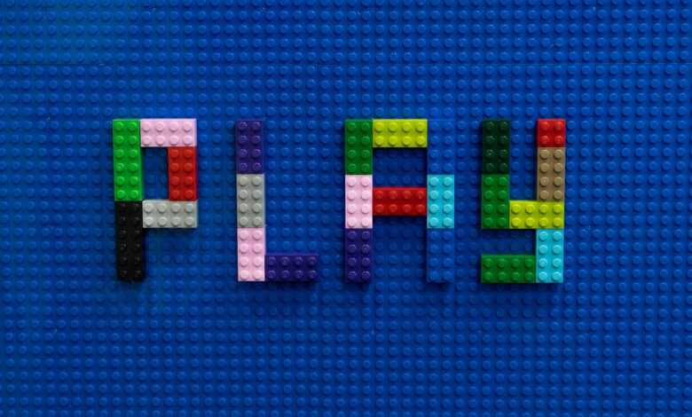 the word play spelled out of legos on a blue surface
