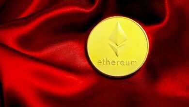 a close up of a red cloth with a gold coin