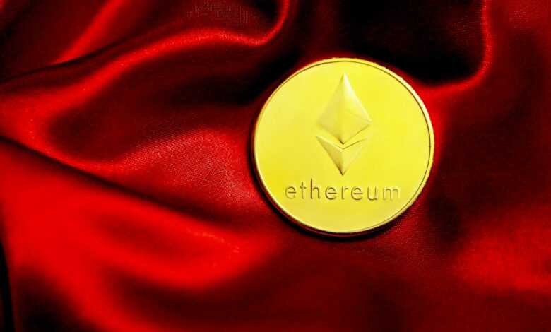 a close up of a red cloth with a gold coin