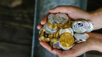 A close-up of hands holding various cryptocurrency coins, representing digital finance.