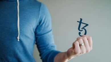 a man in a blue hoodie is holding a piece of paper